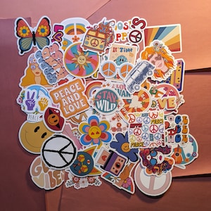 May include: A collection of colorful, retro-style stickers with a peace and love theme. Designs include a butterfly, flowers, peace signs, a VW bus, and the words "Peace and Love", "Stay Wild", and "It's Time".