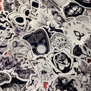 Puede incluir: Una colecci&oacute;n de pegatinas en blanco y negro con varios dise&ntilde;os g&oacute;ticos y ocultos. Las pegatinas presentan im&aacute;genes de calaveras, rosas, manos, tableros Ouija y otros s&iacute;mbolos m&iacute;sticos. La frase "CREATE YOUR OWN FUTURE" es visible.