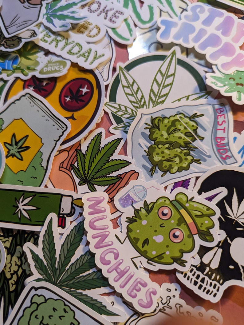 May include: A collection of colorful stickers featuring cannabis-related designs. Stickers include images of marijuana leaves, buds, and cartoon characters. Text includes "Munchies", "Best Buds", and "Stay Trippy".