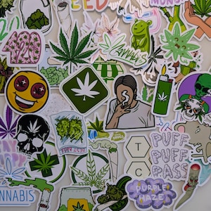 Può includere: Una collezione di adesivi colorati a tema cannabis. I disegni includono foglie di marijuana, faccine sorridenti, teschi e testo come "Cannabis", "Puff Puff Pass" e "Purple Haze". Gli adesivi variano in forma e dimensione.