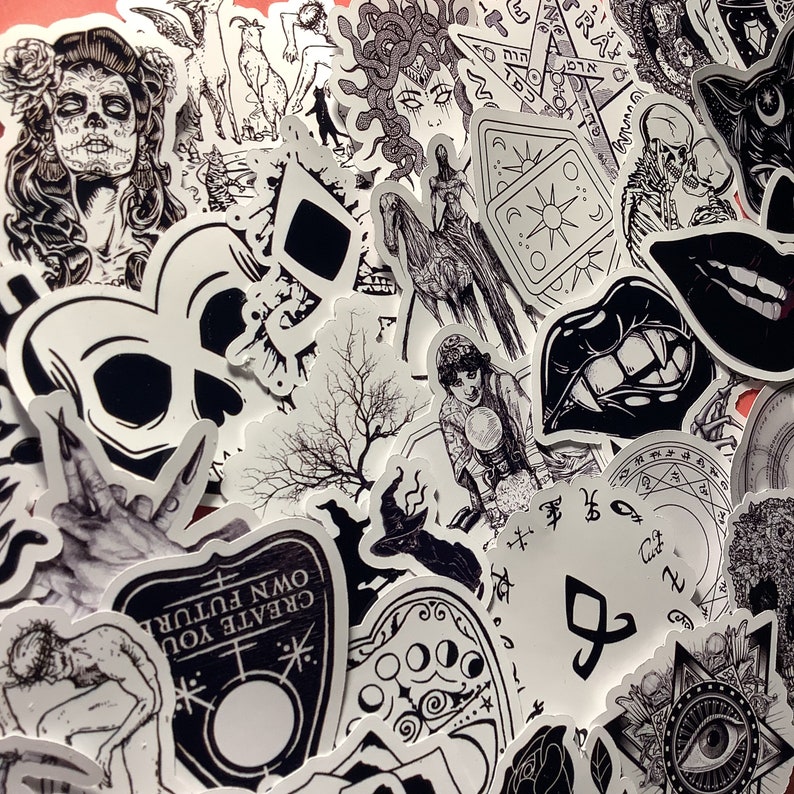 Puede incluir: Una colecci&oacute;n de pegatinas en blanco y negro con varias ilustraciones g&oacute;ticas y ocultas. Los dise&ntilde;os incluyen calaveras, Medusa, cartas del tarot, una bruja, una tabla Ouija y otros s&iacute;mbolos m&iacute;sticos. Las pegatinas est&aacute;n dispuestas sobre un fondo rosa.