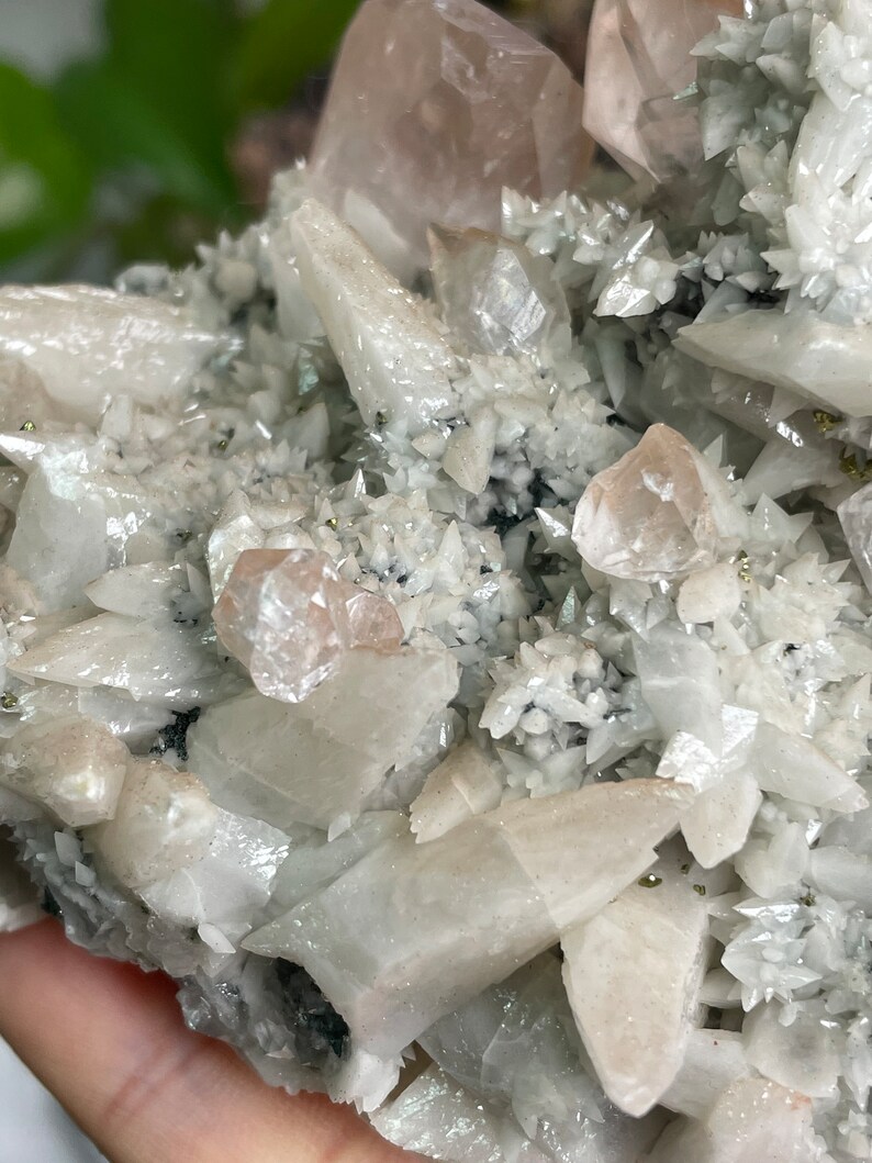 May include: A cluster of white and pink crystals with a sparkly, iridescent finish. The crystals are arranged in a random, organic pattern, creating a visually interesting and unique piece.