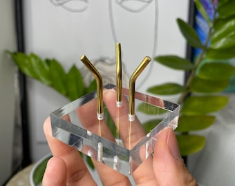 Expositor de minerales con tres patas de metal y base acrílica