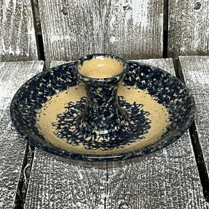 May include: A ceramic condiment server with a central, raised holder and a surrounding plate. The server features a speckled navy blue and tan color scheme. The plate is approximately 7 inches in diameter.