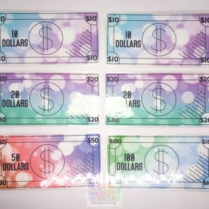 May include: Six colorful play money bills with different denominations: $10, $20, $50, and $100. Each bill has a dollar sign and the amount written out.