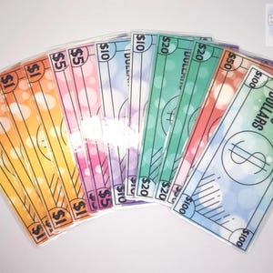May include: A set of colorful play money bills with different denominations, including $1, $5, $10, $20, $50, and $100. The bills have a light, bubbly background and are printed with black text and lines.