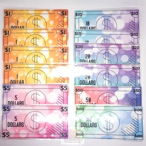 May include: A set of colorful play money bills with different denominations, including $1, $5, $10, $20, $50, and $100. The bills have a watercolor background with a dollar sign and the amount written on each bill.