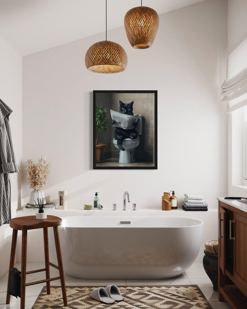 May include: A black cat sitting on a toilet reading a newspaper in a framed print. The print is hanging in a bathroom with a white bathtub, a wooden stool, and a brown rug.