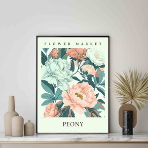 Może przedstawiać: Wydruk w ramie z kwiatowym wzorem przedstawiającym r&oacute;żowe i białe piwonie z zielonymi liśćmi. Wydruk zawiera tekst "FLOWER MARKET" u g&oacute;ry i "PEONY" u dołu.