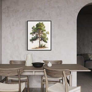 May include: A framed watercolor painting of a green pine tree on a white background. The painting is hanging on a light gray wall in a dining room with a wooden table and chairs.