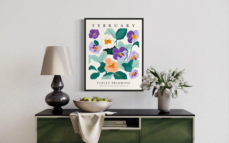 Puede incluir: Una impresi&oacute;n enmarcada con un dise&ntilde;o floral que presenta flores moradas, blancas y naranjas con hojas verdes. La impresi&oacute;n tiene el texto "FEBRUARY" y "VIOLET PRIMROSE" con las palabras "MODESTY, PATRIOTISM, YOUNG LOVE" debajo.