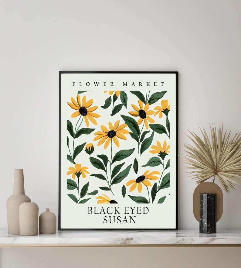 May include: A framed print with a white background and a pattern of yellow black-eyed Susan flowers with green leaves. The print has the text "FLOWER MARKET" at the top and "BLACK EYED SUSAN" at the bottom.