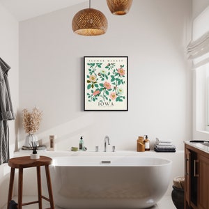 May include: A white bathtub with a white towel on the side, a wooden stool, and a framed print of a floral design with the text "Flower Market, Iowa" on a white background.