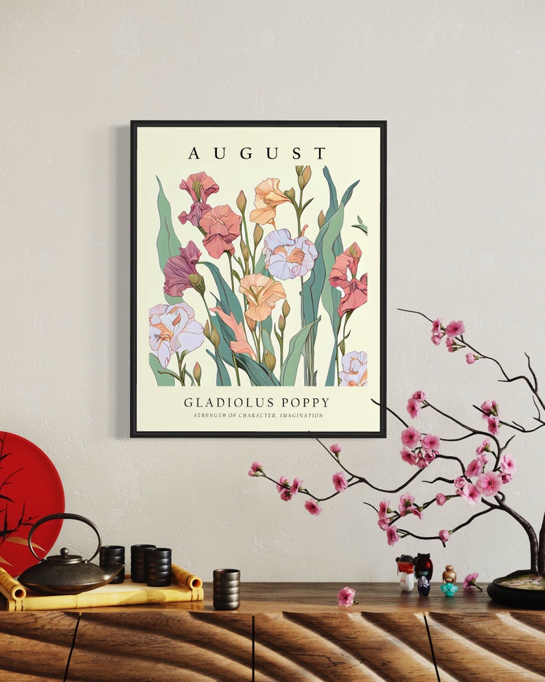 May include: A framed print with a vintage aesthetic featuring a bouquet of pink, white, and orange gladiolus flowers with green leaves. The print has the text "AUGUST" at the top and "GLADIOLUS POPPY" with the text "STRENGTH OF CHARACTER, IMAGINATION" below the flower illustration.