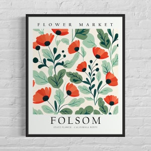 May include: A black framed poster with a floral pattern of red poppies and green leaves. The poster says "FLOWER MARKET" at the top and "FOLSOM" at the bottom with the text "STATE FLOWER - CALIFORNIA POPPY".