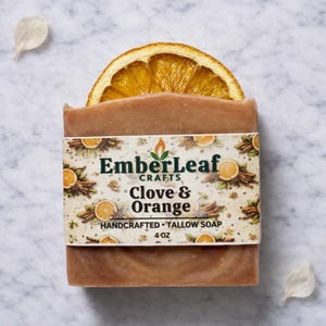 Tallow bar soap bundle by EmberLeaf Crafts. The image shows a variety of colorful, natural soaps—Rose Flower, Citrus Grove, and Oak & Elderberry—neatly laid out on a clean marble surface with scattered white flower petals.