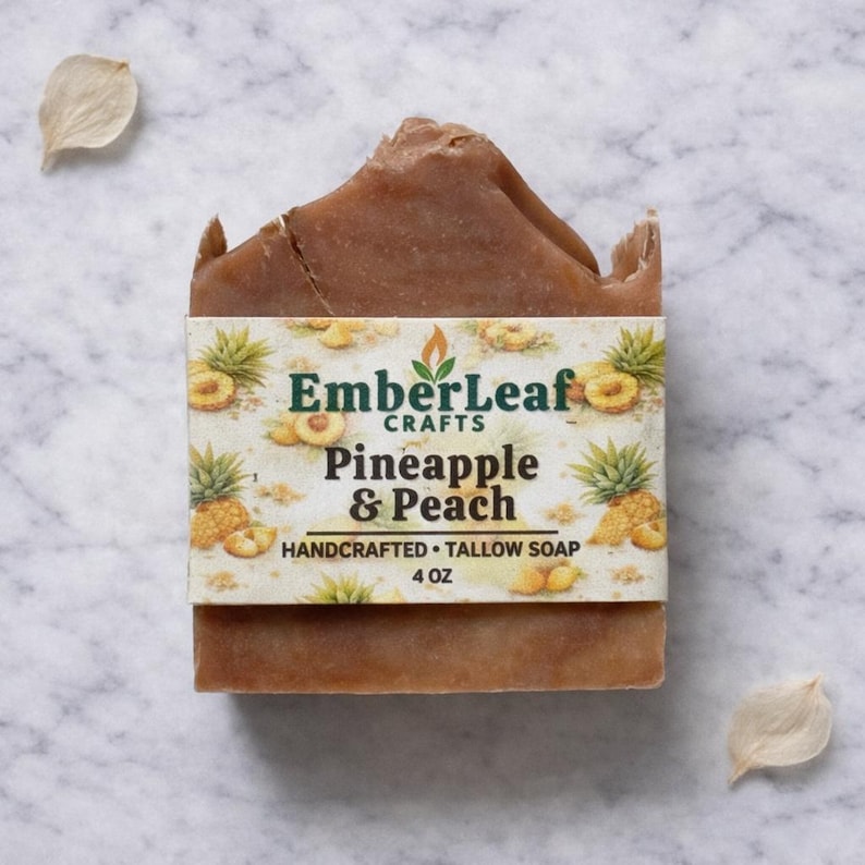 Tallow bar soap bundle by EmberLeaf Crafts. The image shows a variety of colorful, natural soaps—Rose Flower, Citrus Grove, and Oak & Elderberry—neatly laid out on a clean marble surface with scattered white flower petals.