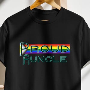 May include: Black t-shirt with a rainbow stripe and the text "PROUD AUNCLE" in green.