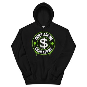 May include: Black hooded sweatshirt with a neon green and white graphic. The graphic features a dollar sign inside a circle with the text "DON'T ASK ME" and "CASH APP ME". The design has a spray paint effect.