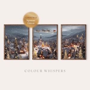 Op de afbeelding: Een set van drie ingelijste wandkunstprints met een besneeuwd winterdorp in de nacht met verlichte huizen, dennenbomen en een vliegende arrenslee met rendieren. De tekst CHRISTMAS Signature Edition en COLOUR WHISPERS is zichtbaar.