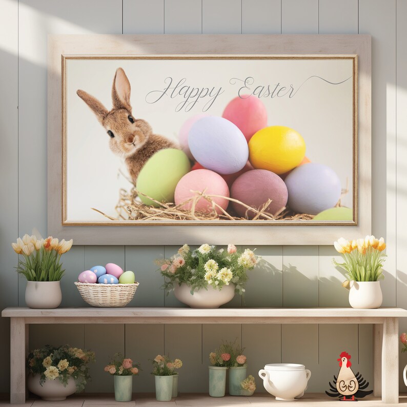 Puede incluir: Una impresi&oacute;n enmarcada con un conejo marr&oacute;n asom&aacute;ndose de un nido de huevos de Pascua coloridos. La impresi&oacute;n tiene el texto "Happy Easter" en una fuente cursiva.