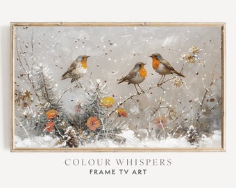 May include: A framed painting depicting three robins perched on branches in a snowy winter scene. The birds are brown and orange with white breasts. The background is a soft grey with white snow falling. The painting is titled "Colour Whispers" and "Frame TV Art".
