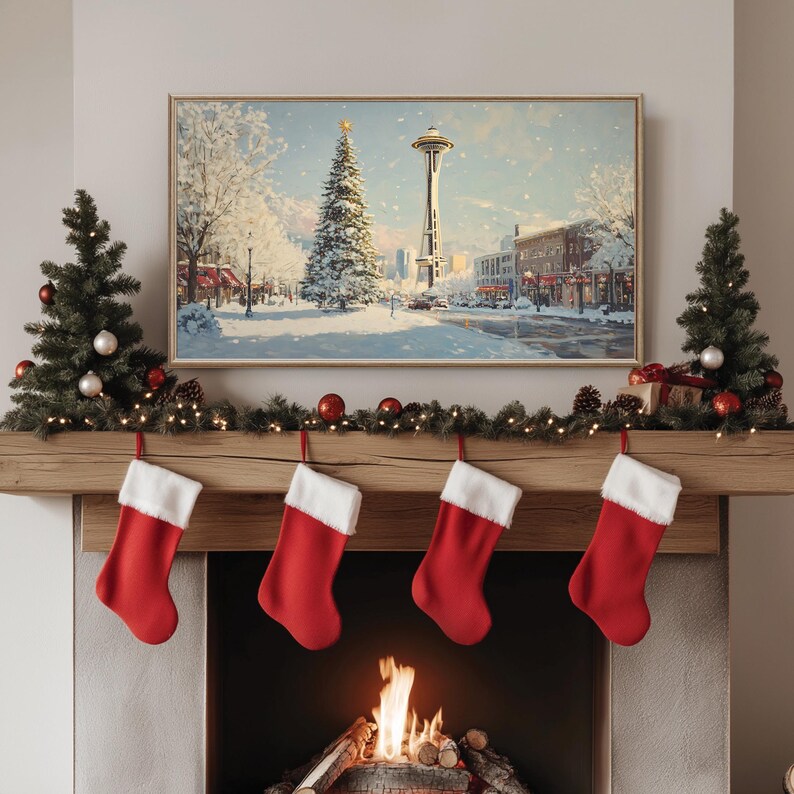 May include: A snowy winter scene with a Christmas tree and the Space Needle in Seattle, Washington. The scene is framed and hanging above a fireplace with stockings hung on the mantle.