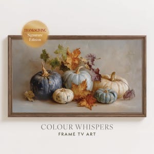 May include: A framed digital artwork titled Thanksgiving Signature Edition and Colour Whispers Frame TV Art featuring a still life of four pumpkins in shades of dark blue, light blue, and cream, surrounded by scattered autumn leaves in brown and gold.