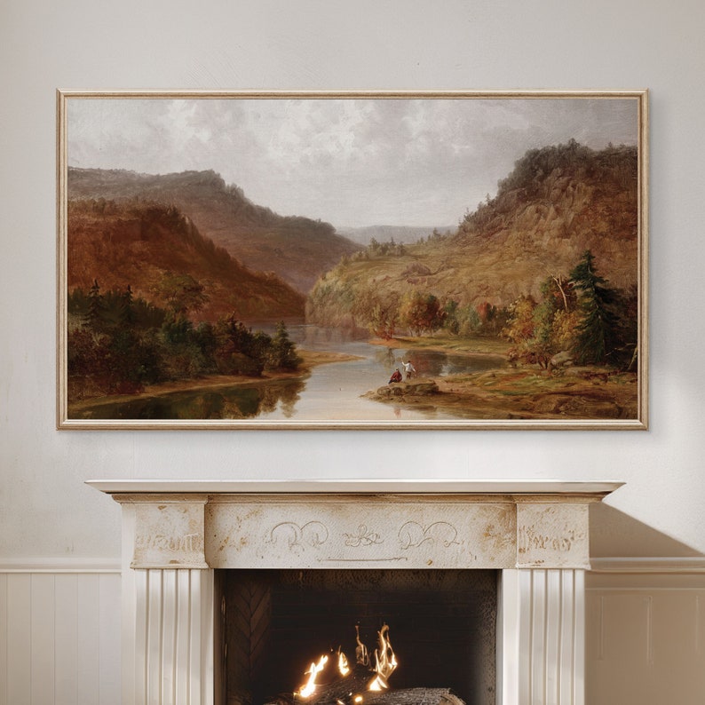 K&ouml;nnte beinhalten: Ein gerahmtes Landschaftsbild, das einen Fluss zeigt, der sich durch ein Tal mit sanften H&uuml;geln und B&auml;umen in Herbstfarben schl&auml;ngelt. Das Bild ist in einem hellen Holzrahmen gefasst und h&auml;ngt an einer wei&szlig;en Wand.