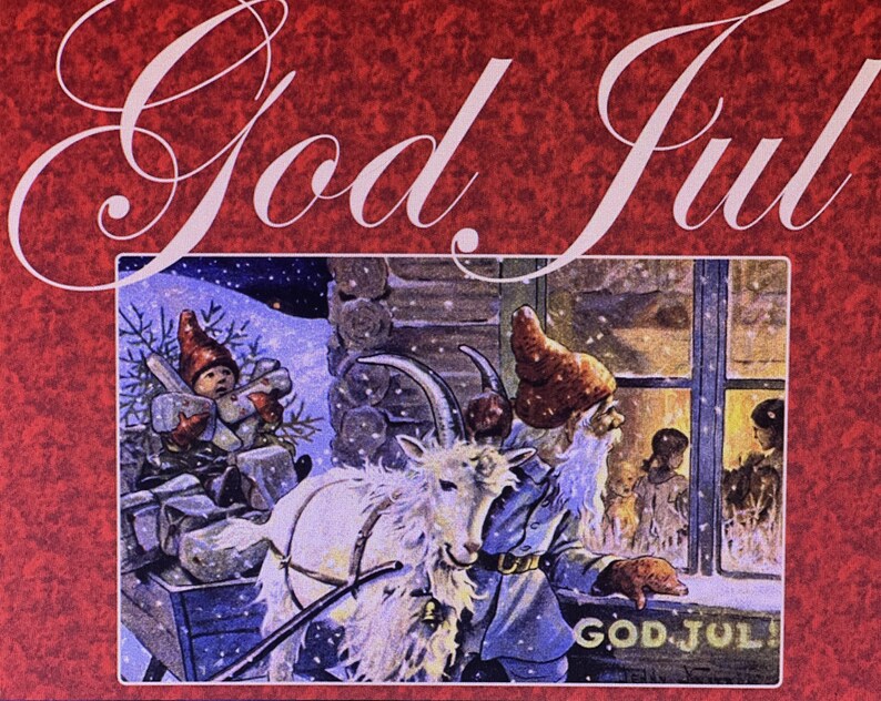 May include: A red card featuring the text God Jul in white script. The central illustration depicts a white goat, a figure with a long white beard and red hat, and a small child in a red hat, all set against a snowy cabin scene with a window.