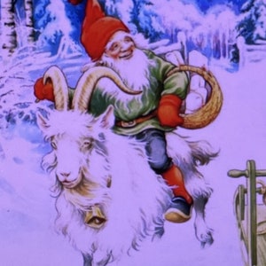 May include: A festive illustration featuring a bearded gnome wearing a red hat, green jacket, and red mittens, riding a white goat with curved horns and a bell around its neck. The gnome carries a woven basket in a snowy, winter forest setting.