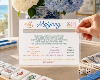 May include: A clear acrylic Mahjong reference card featuring blue script text, red and green Chinese characters, and instructional rules for gameplay. The card lists specific tile combinations and strategies, including the phrase BE SNEAKY! in red.