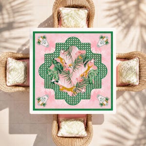 May include: A square tablecloth featuring a pink background with a central green lattice frame. The design includes tropical palm leaves, pink flamingos, and yellow leopards. Four corner motifs display a bottle graphic with the text 'Chandon'.