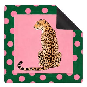 May include: A square mat featuring a central illustration of a leopard with black spots on a tan coat, positioned against a solid pink background. The mat is framed by a dark green border decorated with a repeating pattern of light pink polka dots.