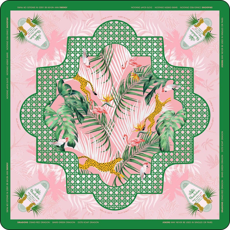 May include: A square scarf featuring a pink background with a central green lattice frame. The design includes illustrations of leopards, flamingos, cockatoos, and tropical palm leaves. The corners display Charleston-themed labels with text.