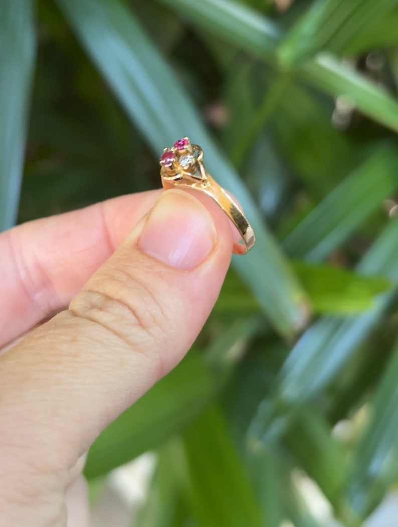 May include: A gold ring with a cluster of red and clear stones.