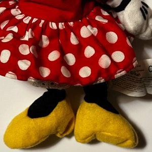 May include: A red and white polka dot dress with yellow shoes. The dress has a ruffled skirt and the shoes are made of soft plush.