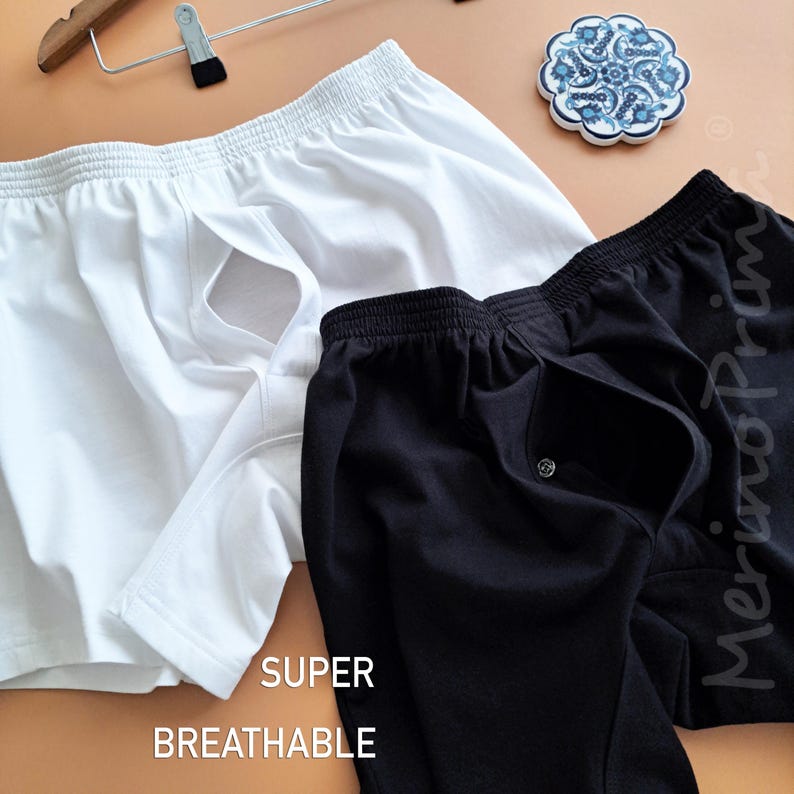 May include: Two pairs of boxer shorts, one white and one black, with a button fly and elastic waistband. The text "SUPER BREATHABLE" is printed on the bottom of the image.