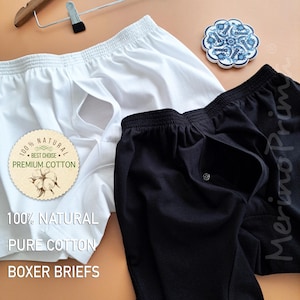以下が含まれることがあります： 白と黒のボクサーブリーフが2枚。コットンラベルには「100% NATURAL BEST CHOICE PREMIUM COTTON 100% NATURAL PURE COTTON BOXER BRIEFS」と記載されています。