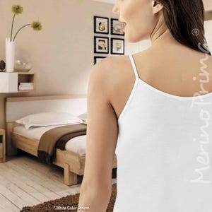 May include: White sleeveless undershirt with thin straps. The undershirt is made of a soft, comfortable fabric. The image shows the back of the undershirt.