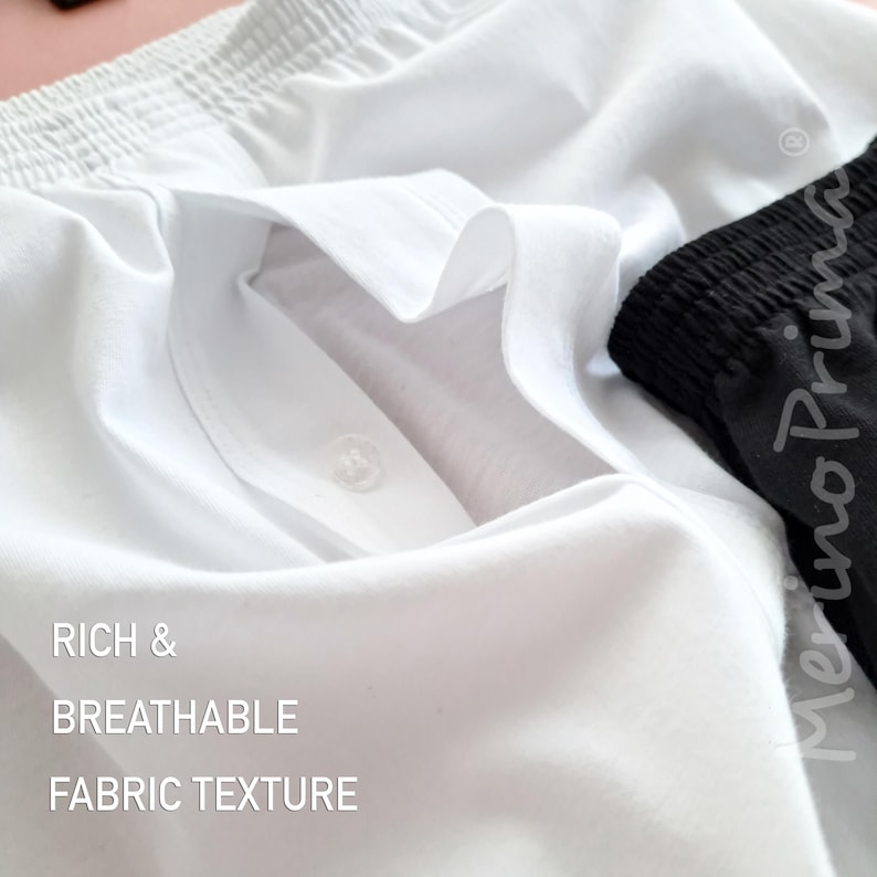 以下が含まれることがあります： ボタンと「RICH & BREATHABLE FABRIC TEXTURE」というテキストが付いた白い生地のクローズアップ。
