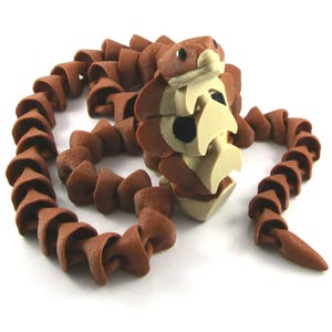 May include: A brown articulated snake toy with a light tan underbelly and head. The snake's body is made of cone-shaped segments, and it has small black eyes. The toy is designed to be flexible and poseable.