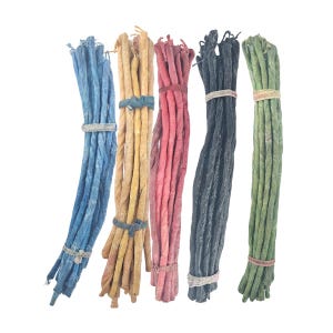 May include: Bundles of twisted, colorful incense sticks. The incense sticks are in shades of blue, tan, red, black, and green. Each bundle is secured with a band. The background is plain white.