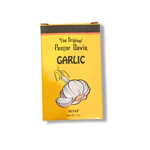 May include: A yellow and black box with a white garlic illustration. The text on the box reads "The Original Pastor Davis Garlic Soap Net Wt. 3 oz."