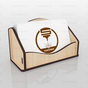 Puede incluir: Un tarjetero de madera de color claro con bordes de color marr&oacute;n oscuro, que contiene una pila de tarjetas de visita blancas. Cada tarjeta presenta un logotipo circular marr&oacute;n de una herramienta de corte l&aacute;ser con el texto STLASER DESIGN ART.