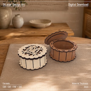 Könnte beinhalten: Zwei runde Holzschachteln mit gewellten Rändern. Eine Schachtel ist geschlossen und zeigt ein lasergeschnittenes Blumenmuster auf dem Deckel mit einem kleinen Herzdetail. Die andere Schachtel ist offen und zeigt einen hohlen Innenraum. Materialstärke 3mm.