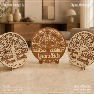 May include: Three circular laser-cut wooden plaques featuring intricate tree designs with heart-shaped leaves. The plaques display the text Brave Family, Grandkids, and Our Family. Each piece is supported by a small wooden stand on a flat surface.