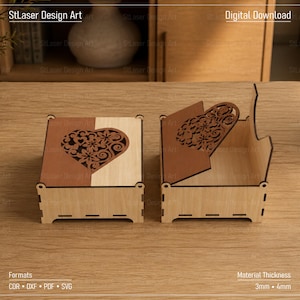 Könnte beinhalten: Zwei quadratische Holzschachteln mit lasergeschnittenen Mustern. Eine Schachtel ist geschlossen und zeigt ein zweifarbiges Design in Braun und hellem Holz mit einem herzförmigen Blumenmuster. Die zweite Schachtel ist geöffnet und zeigt das Innere.
