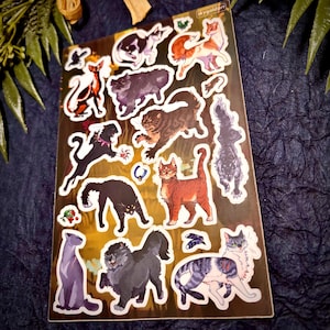 Puede incluir: Una hoja de pegatinas de gatos con varias razas de gatos en diferentes poses y colores. Las pegatinas incluyen gatos en negro, naranja, gris y blanco, algunos con accesorios. Las pegatinas est&aacute;n sobre un fondo dorado.
