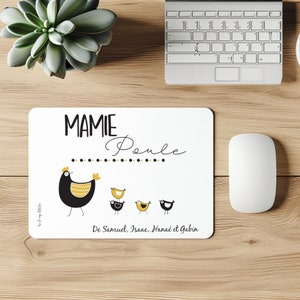 Peut inclure: Tapis de souris rectangulaire blanc avec une illustration de poule noire et jaune et le texte "MAMIE Poule". Les noms "De Samuel, Isaac, Hanaé et Gabin" sont en dessous. Une souris et un clavier d'ordinateur sont visibles.